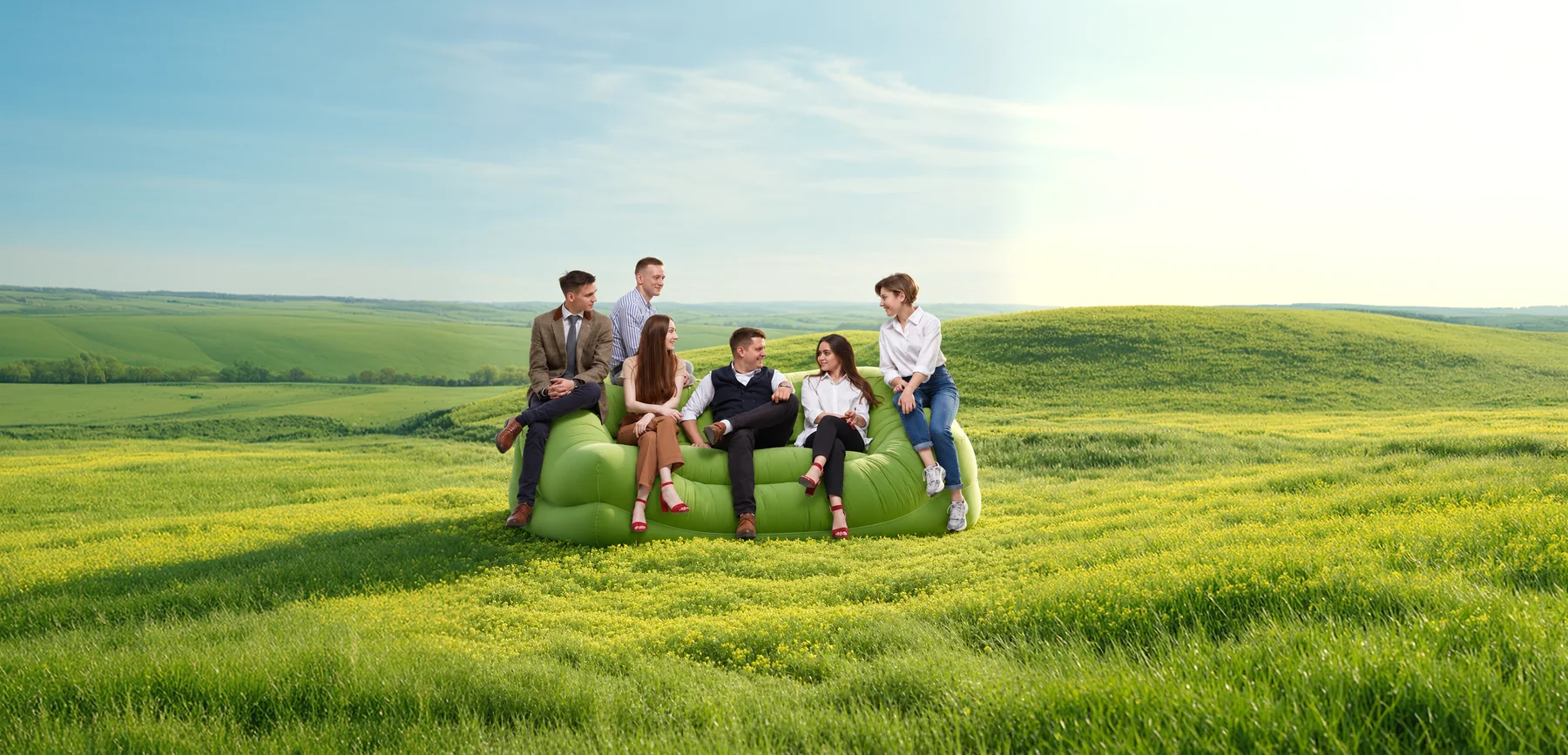 Friends relaxing on a sofa in a meadow